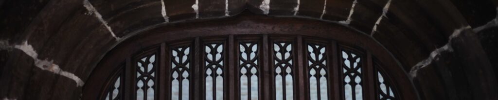 Gothic tracery gate beneath stone arch, Abbaye de la Cambre, Brussels — Human-Dominant